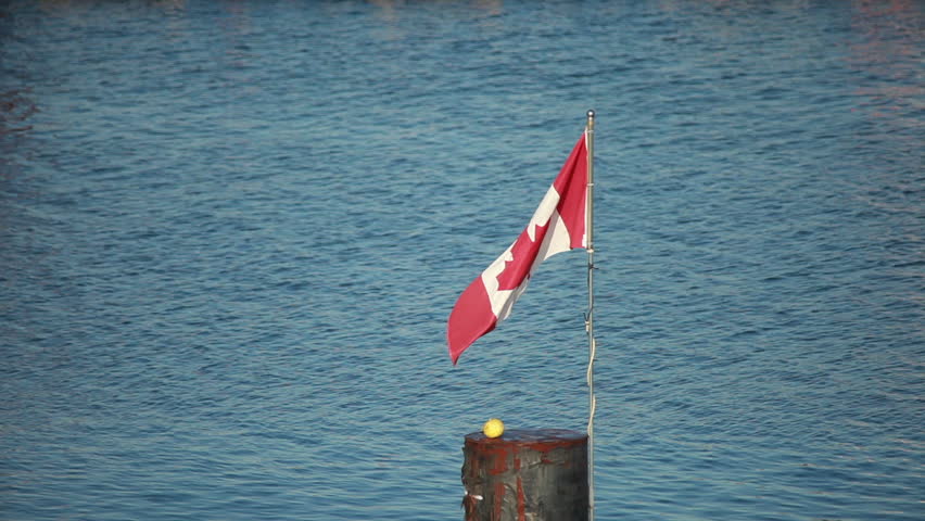 Stationary of Canadian flag waving by the sea