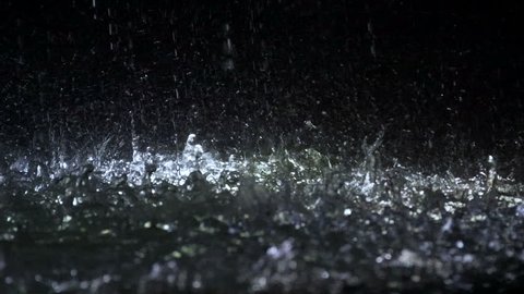 Water drops falling on ground, energy and freshness, illuminated fountain, autumn weather. Clean puddle on asphalt road, nature environment, sprays slow motion, meteorology. Renewal and new start
