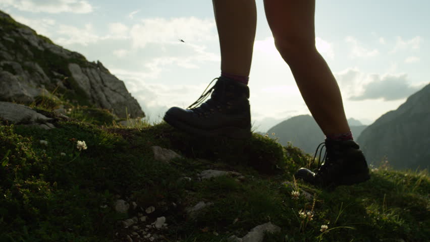 SLOW MOTION, CLOSE UP: Detail of vintage leather mountaineering boots and unrecognizable adventurous female hiker climbing mountain peak, hiking uphill on beautiful sunny summer day in European Alps Royalty-Free Stock Footage #20183806