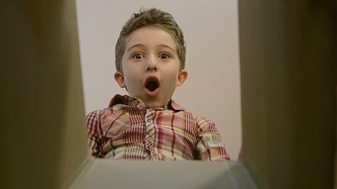 Little boy opens a parcel box with different versions of emotions and being surprised.