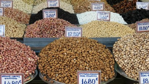 tilt up shot of a table with various nuts and dried fruits for sale at athens central market