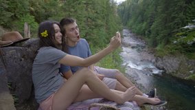 Adventurous Couple Take Selfies Together On A Cliff, Overlooking A River - Powered by Shutterstock - Get 15% off with code: PIKWIZARD15