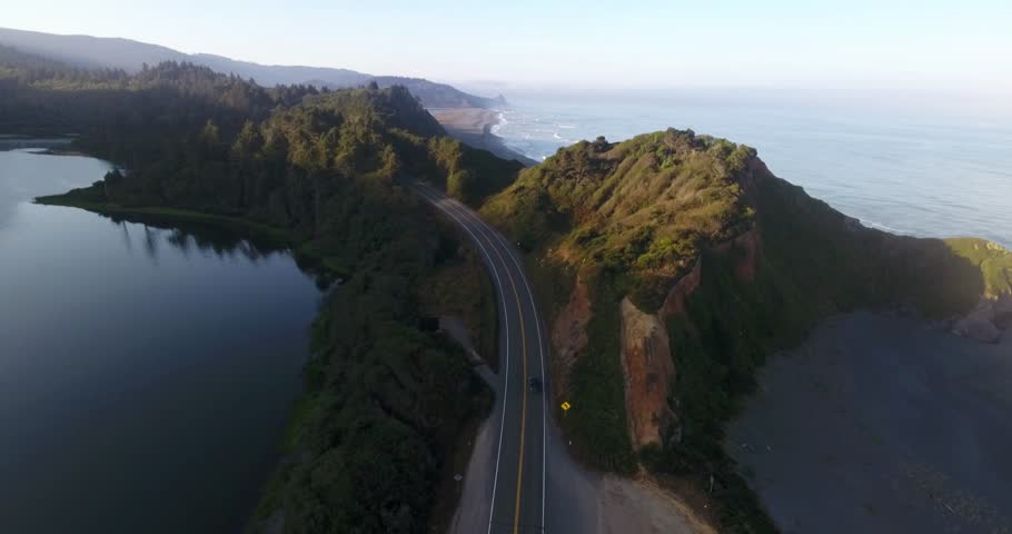 Aerial shot of a car driving on a State Route 1 - the Pacific Coast Highway in California, USA