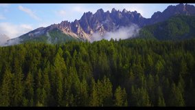 Aerial view of Dolomiti mountain in summer, a suggestive aerial video in the dolomiti above a forest at the sunset