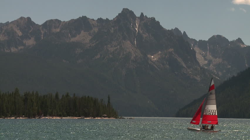 Lake and mountains in Yellowstone National Park with a sailboat passing by