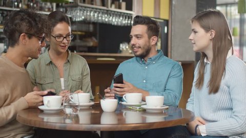 Group of Young Mixed race People using Phones in Coffee Shop. Shot on RED Cinema Camera in 4K (UHD).