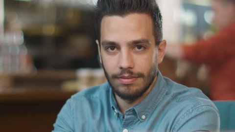 Portrait of Hispanic Ethnicity Young Man at Cozy Coffee Shop. Shot on RED Cinema Camera in 4K (UHD).