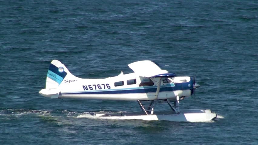 SEATTLE, WASHINGTON, USA - CIRCA 2011; Blue float-plane taxiing in ocean inlet
