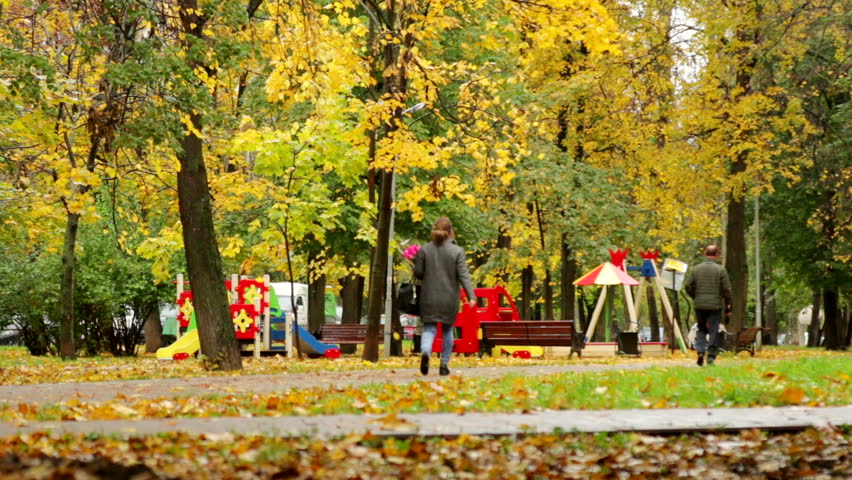 Beautiful nature scene of Autumn Leaves and hurrying people in autumnal Park. Timelapse