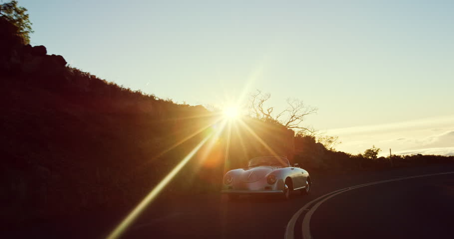 Happy couple driving on country road into the sunset in classic vintage sports car | Shutterstock HD Video #20219098