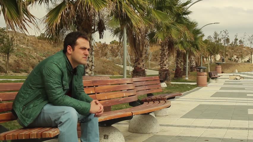 Worry and thinking man sitting looking to the sea at the coast
