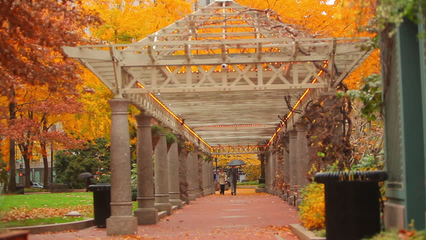 Columned structure in autumn with pedestrians walking in downtown Boston, MA