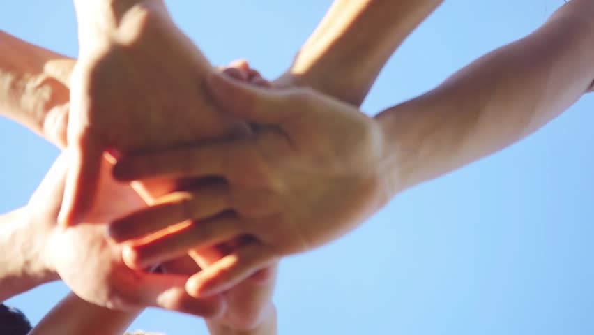 Successful team: many hands holding together on sky background in slowmotion. 1920x1080 | Shutterstock HD Video #20240959