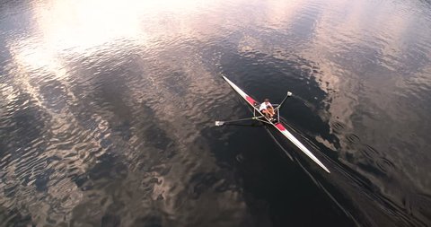 Scull rowing training at sunset. Aerial view 4k super wide