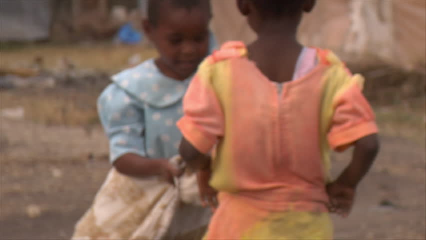 Kenya - Circa 2006: Two unidentified little girls wrap themselves in a thin