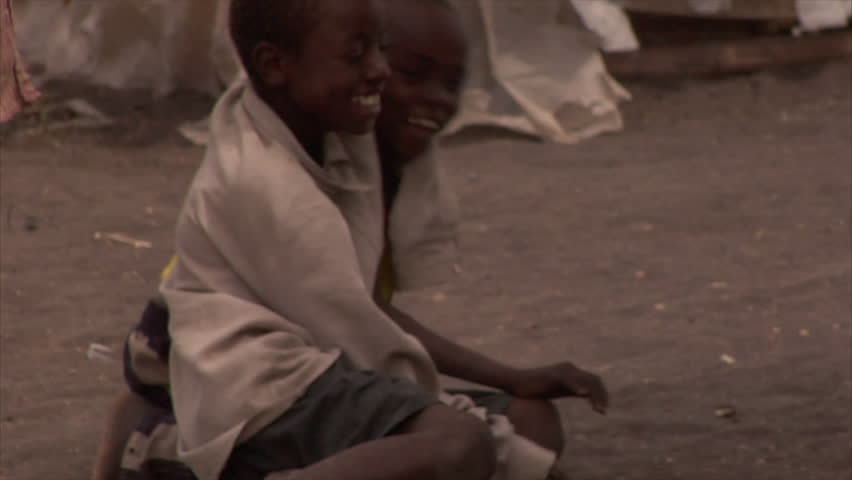 Kenya - Circa 2006: Three unidentified boys play on the ground in raggedy