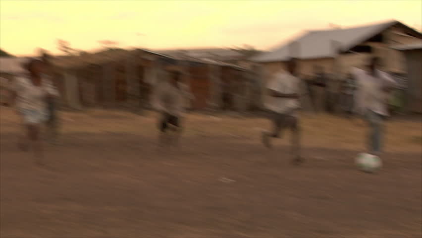 KENYA - CIRCA 2006: Unidentified boys play soccer in the street at sunset circa
