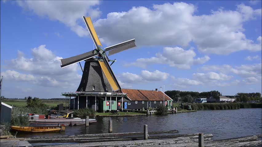 Dutch windmill working on canal of Zaanse Schans in Holland, Netherlands