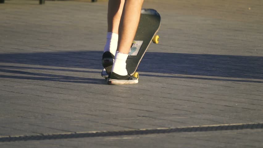 Young skateboarder kick turns his skateboard in the air, slow motion