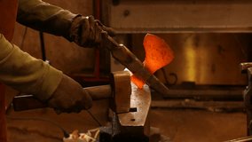 The blacksmith forging the molten metal on the anvil 