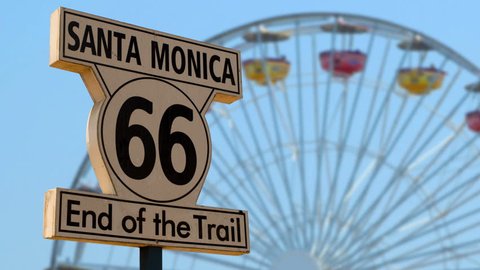 End of the Route 66 trail sign with the Santa Monica Pier Ferris wheel in the background
