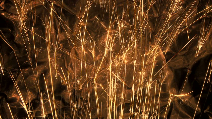 Gold sparks shoot into copper metal background