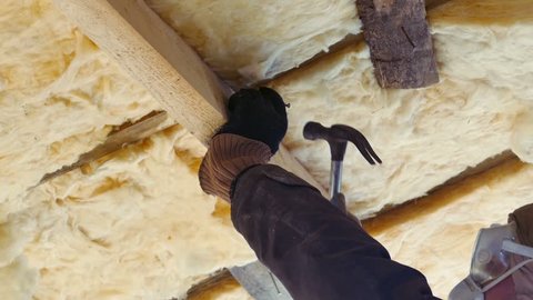 Man Repairing and Insulating the Roof With Fiberglass (Glasswool), 4k Ultra hd Closeup Shot
