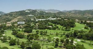 4K Helicopter aerial view flying over Marbella golf course near mountains. Spain 2016