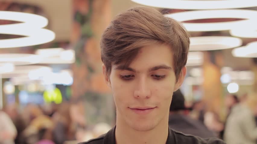 Young men eat hamburger at food court in shopping mall. He don't like it and put away with disgust Royalty-Free Stock Footage #20288416