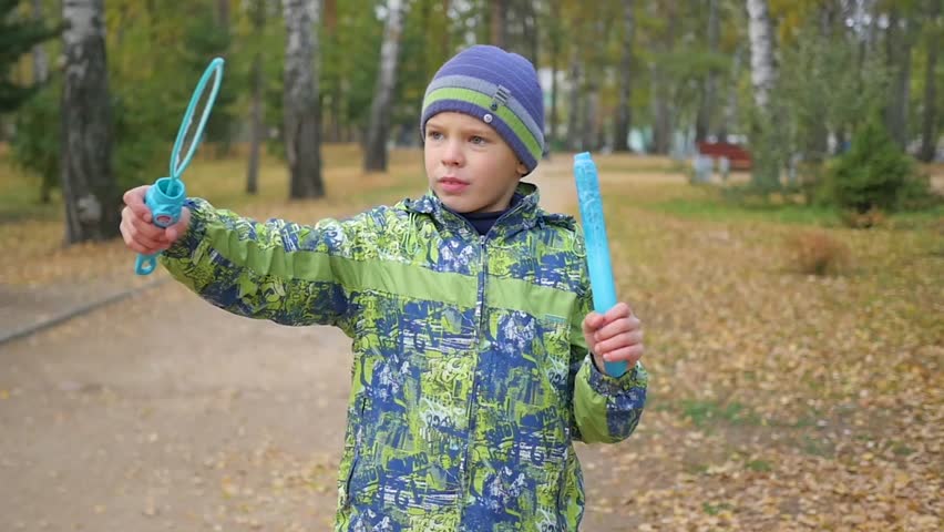 boy makes big soap bubbles in the Park with delight
