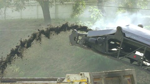 Cold milling machine, milled asphalt falls into the back of the truck, super slow motion