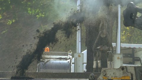 Cold milling machine grinds asphalt, slow motion