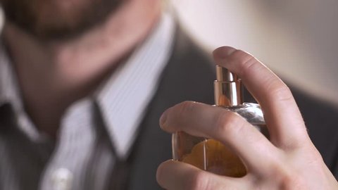 close up of handsome young business man using perfume