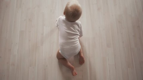 Cute baby with beautiful blue eyes on the white background creeps. Top View action concept Stock Video