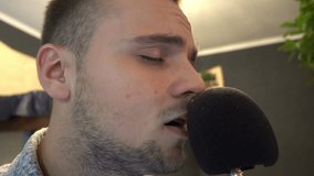 Young Man Singing Into Microphone In Studio audio recording 