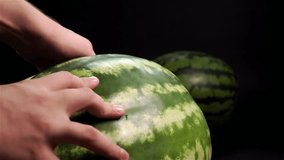 Slow motion. Man hand put piece of fresh tasty wet green stripet watermelon with red pulpy fruity juicy rich succous. Black bg. Ossicles and bones. Close up static shot. High-speed camera. - Powered by Shutterstock - Get 15% off with code: PIKWIZARD15