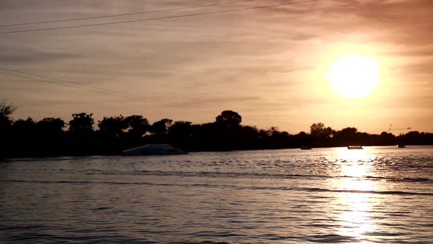 Wake Boarder Traveling Left to Right and Doing a Half Somersault in Silhouette against the Setting Sun on Quiet Waters Park Lake, Deerfield Beach, Florida Royalty-Free Stock Footage #20308573