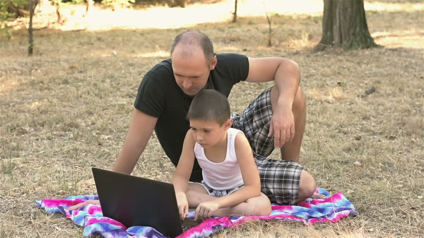 Father with son doing homework at the laptop