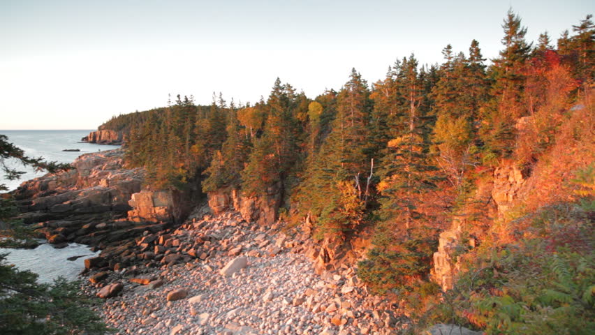 The first moment of sunrise light on Monument Cove in Acadia National Park, Maine on a clear, crisp Autumn day.