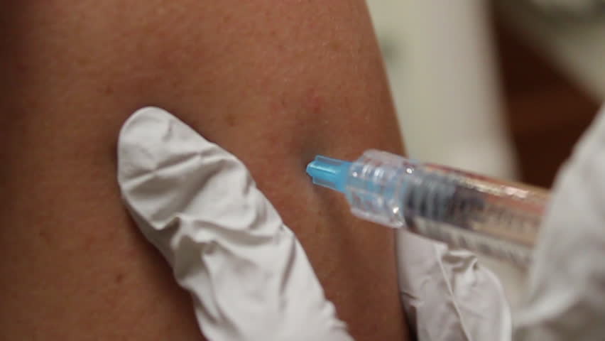 A person's arm getting a shot.
