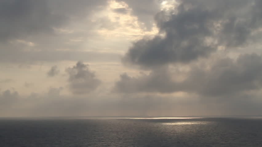 A view of a cloudy sky above a calm ocean.