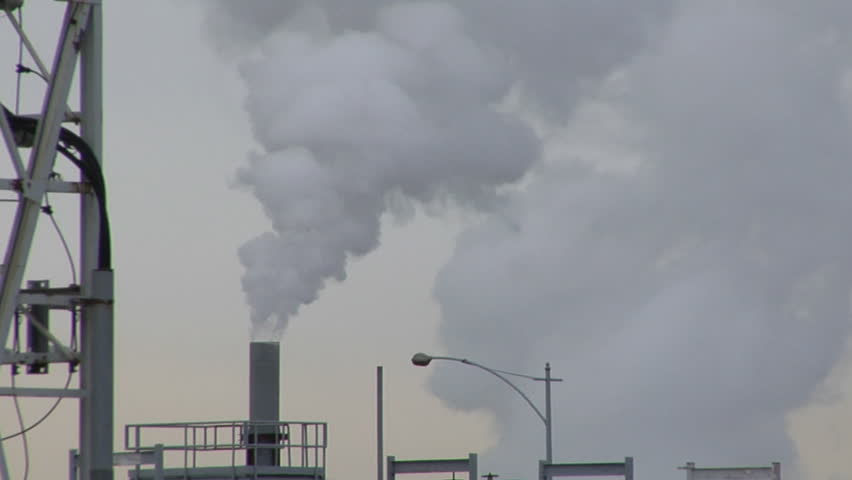 Camera moving left to right, showing a smoke stack and another building.