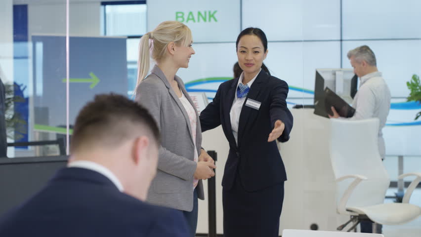 4K Modern city bank with customers & staff, 1 man assisting customer & getting signature on document. Shot on RED Epic. | Shutterstock HD Video #20321740