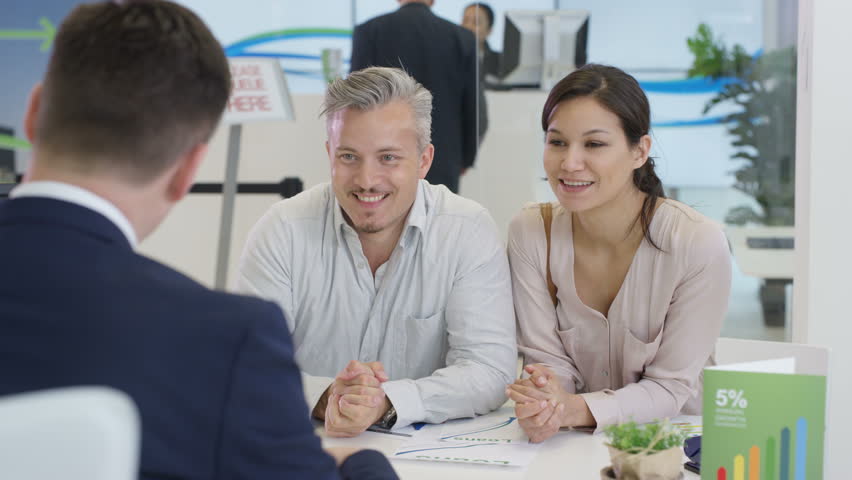 4K Modern city bank with customers & staff, happy couple talking to adviser & signing document. Shot on RED Epic. | Shutterstock HD Video #20321749
