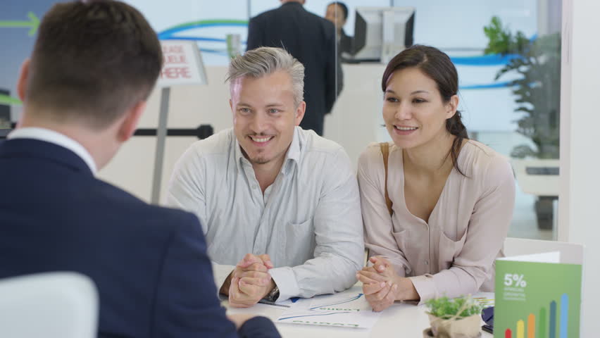 4K Modern city bank with customers & staff, happy couple talking to adviser & signing document. Shot on RED Epic. | Shutterstock HD Video #20321773