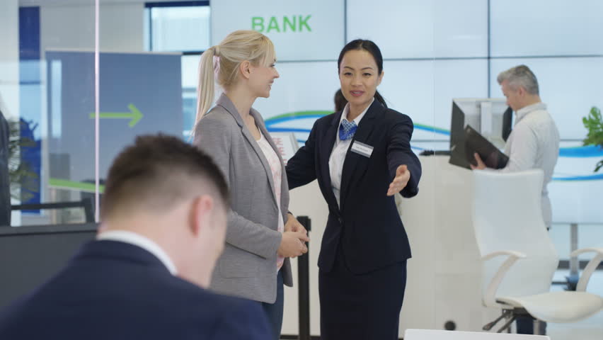 4K Modern city bank with customers & staff, 1 man assisting customer & getting signature on document. Shot on RED Epic. | Shutterstock HD Video #20321782
