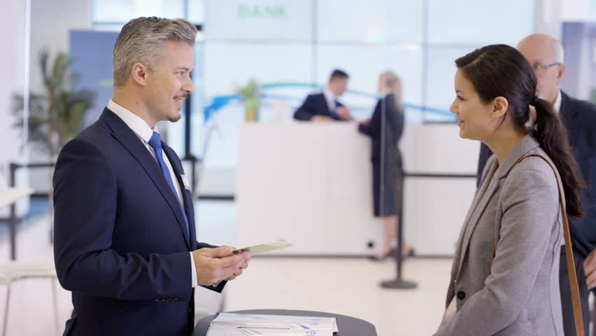 4K Friendly bank workers talking to customers & offering financial advice. Shot on RED Epic. | Shutterstock HD Video #20322466