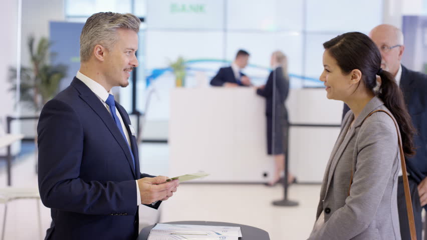 4K Friendly bank workers talking to customers & offering financial advice. Shot on RED Epic. | Shutterstock HD Video #20322484