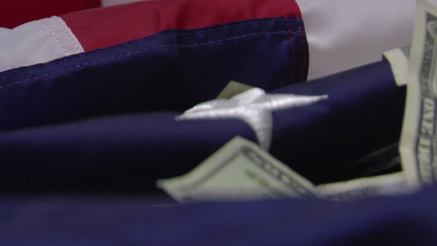 Close up of American flag with Dollar Bills