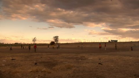 Unidentified boys play soccer in the street in the evening circa 2006 in Kenya.
